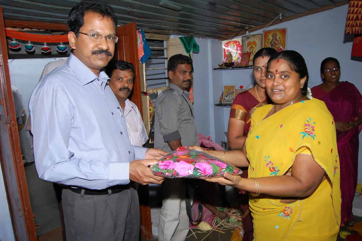 Theni District Collector Mr. Palanichamy receiving handicraft artwork during visit to NWDT