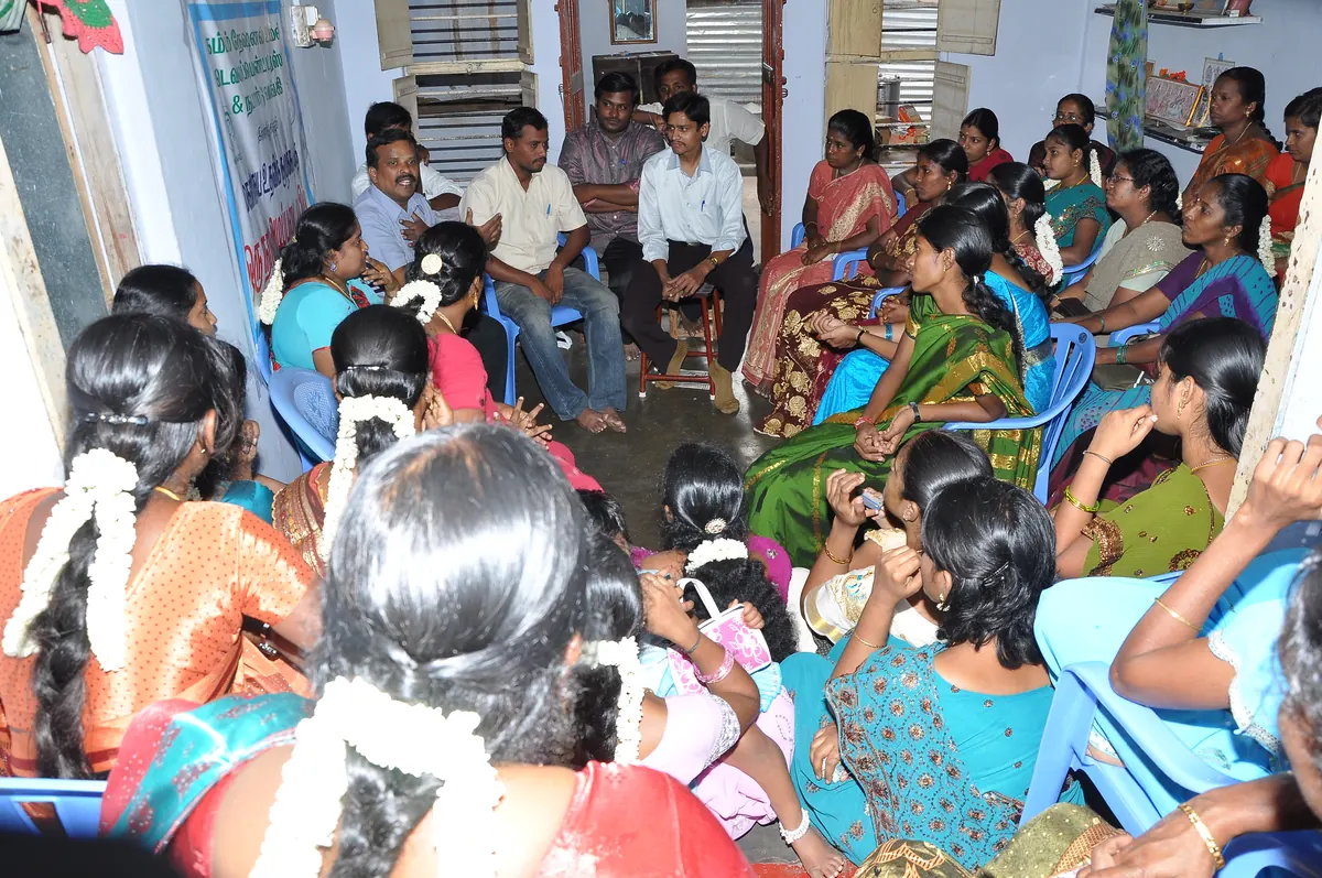 Women SHG members seated in a discussion circle reviewing savings and group management
