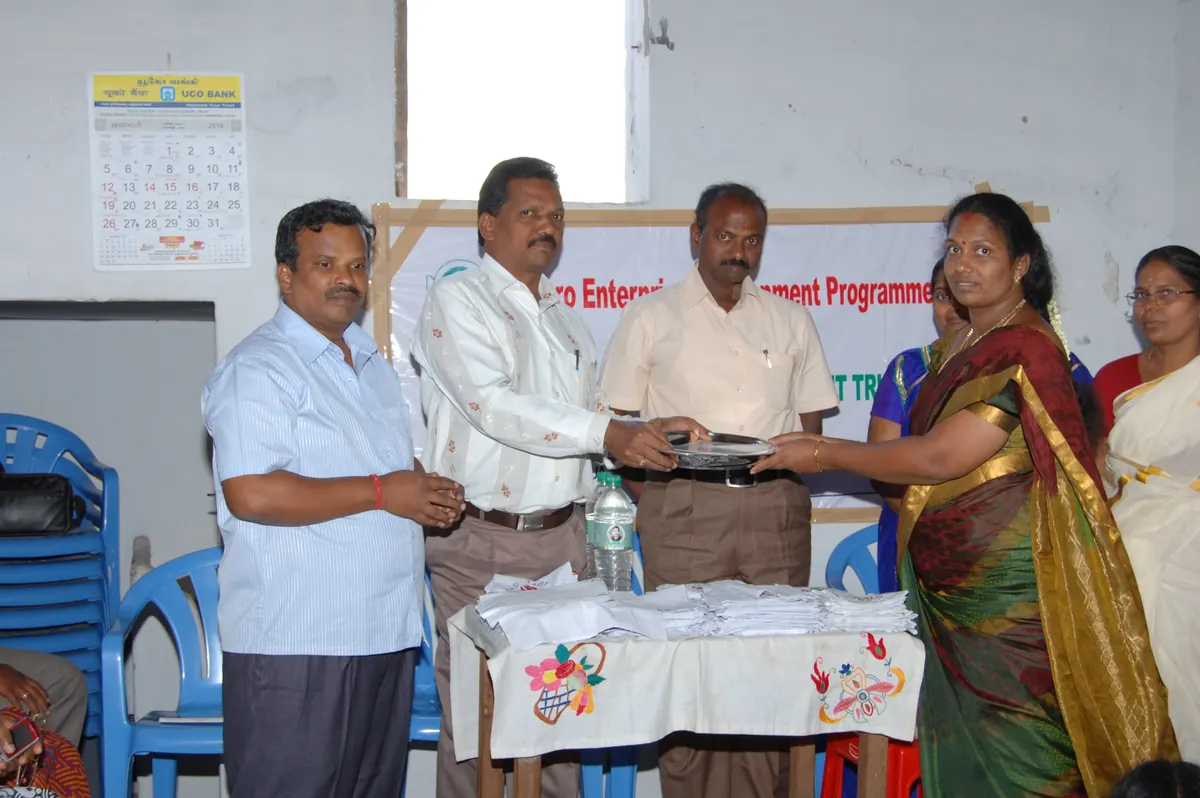 Officials presenting livelihood kit and financial inclusion documents to women SHG member